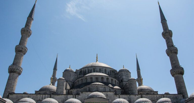 Exterior view of the Blue Mosque’s domes and six minarets under a clear sky in Istanbul
