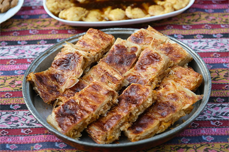 Flaky cheese börek slices served on a white plate