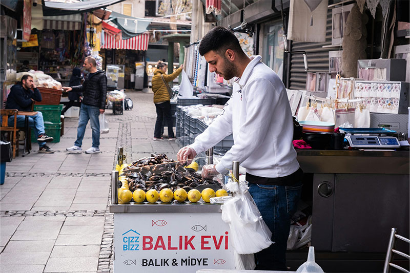 Street vendor serving stuffed mussels with lemon