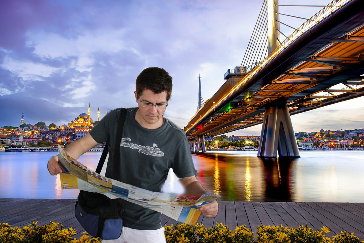 Tourist checking a city map in front of the Golden Horn Bridge with Suleymaniye Mosque in the background
