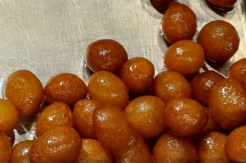 Lokma are small balls of deep-fried dough soaked in syrup, resembling miniature donuts.