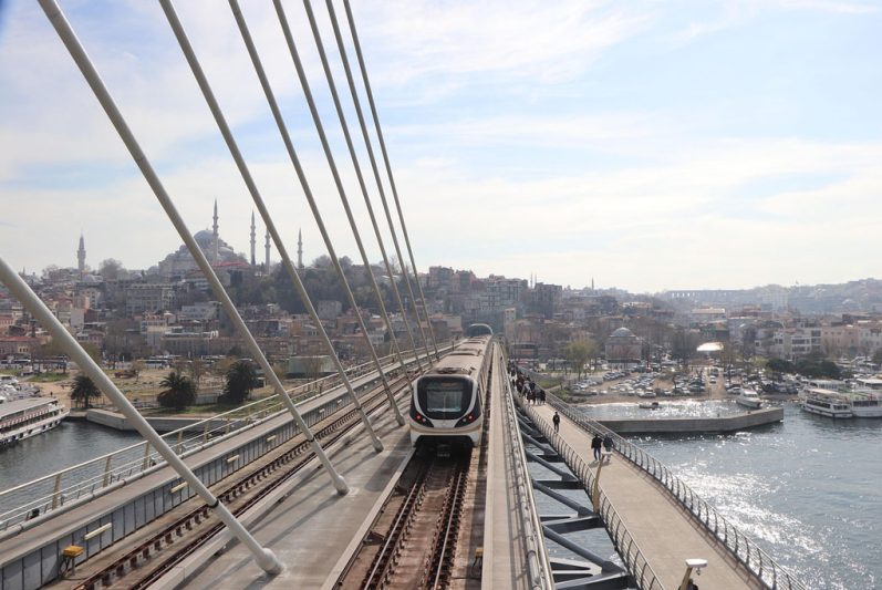 Istanbul Metro train crossing the Golden Horn Bridge with city view